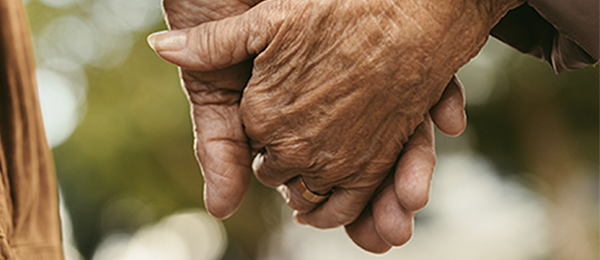 A couple walking together and holding hands while on an outdoor stroll
